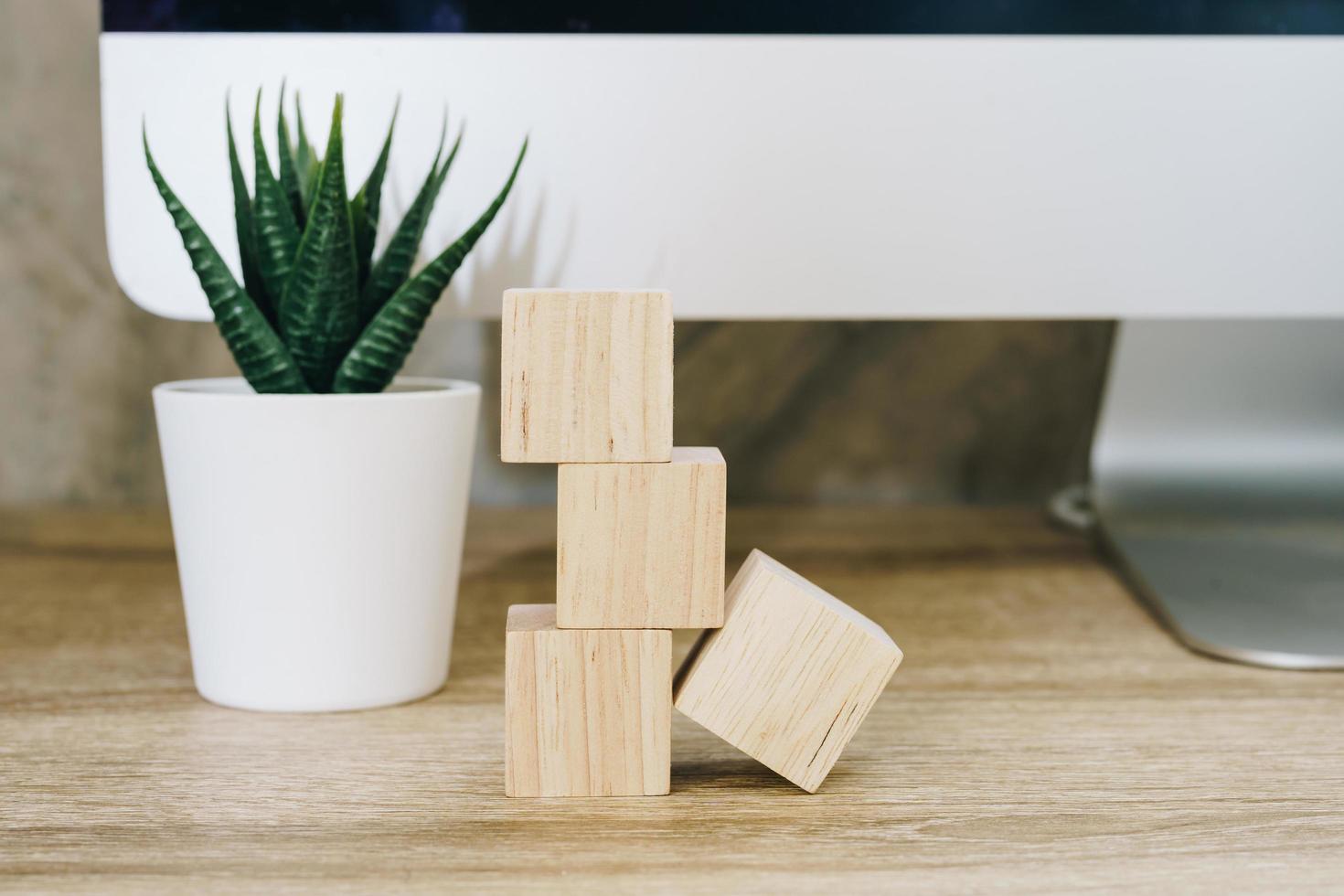 Four wooden toy cubes on wooden table background with copy space photo