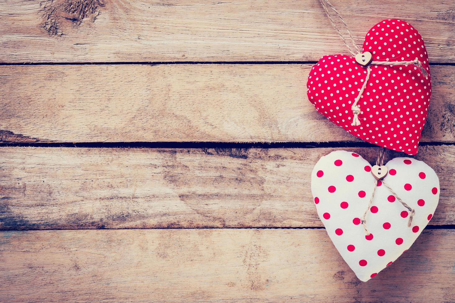 dos corazón tela en de madera mesa antecedentes. foto