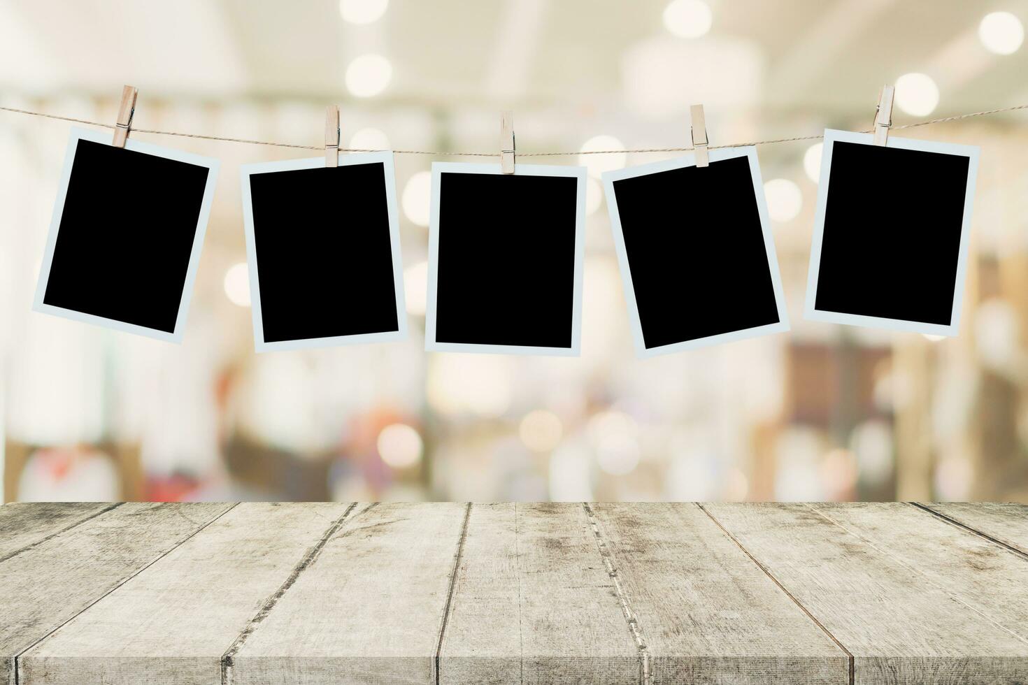 Empty wood table and instant photo hanging on blur image background of people display montage for product.