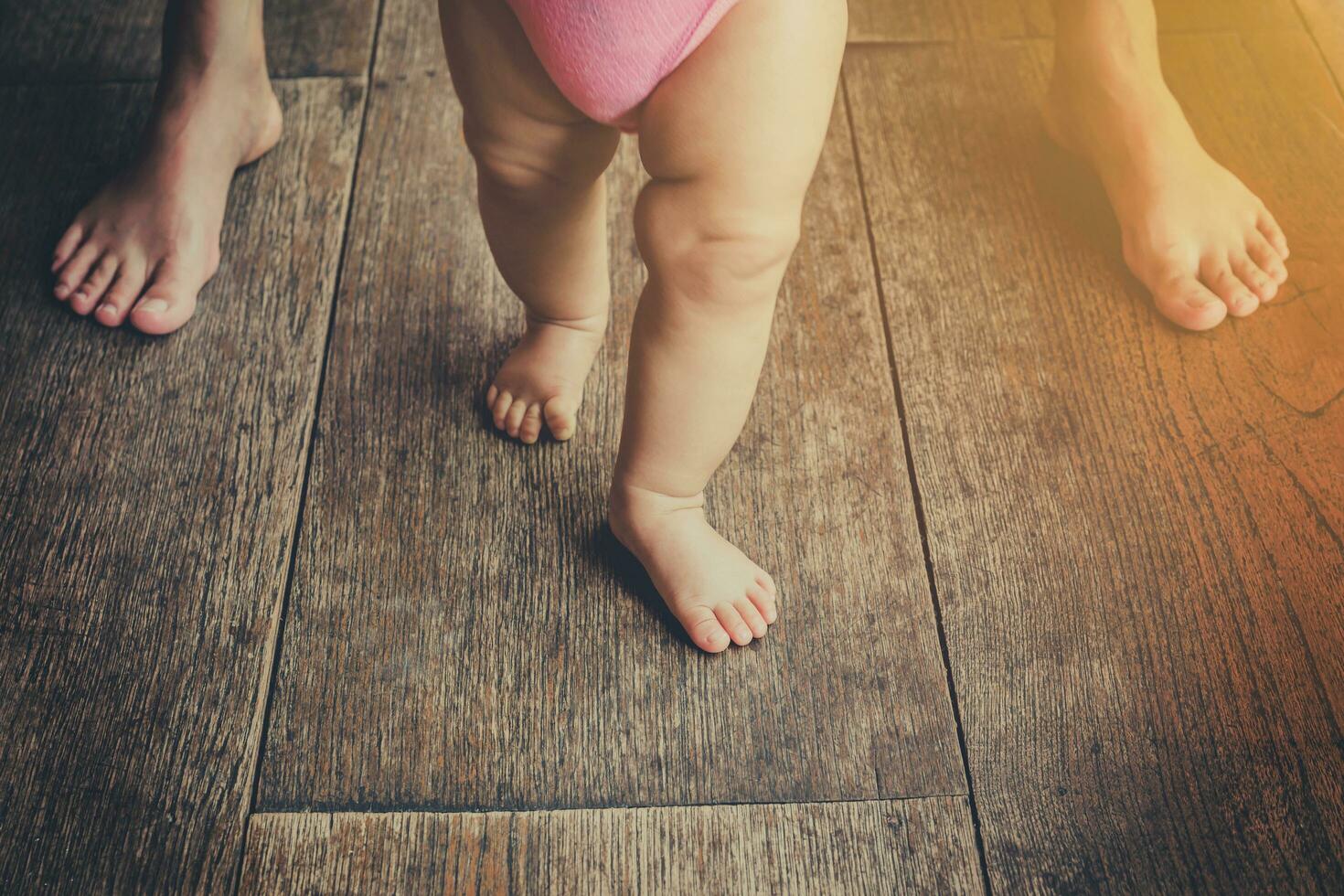 Baby leaning walking with mother, vintage toned. photo