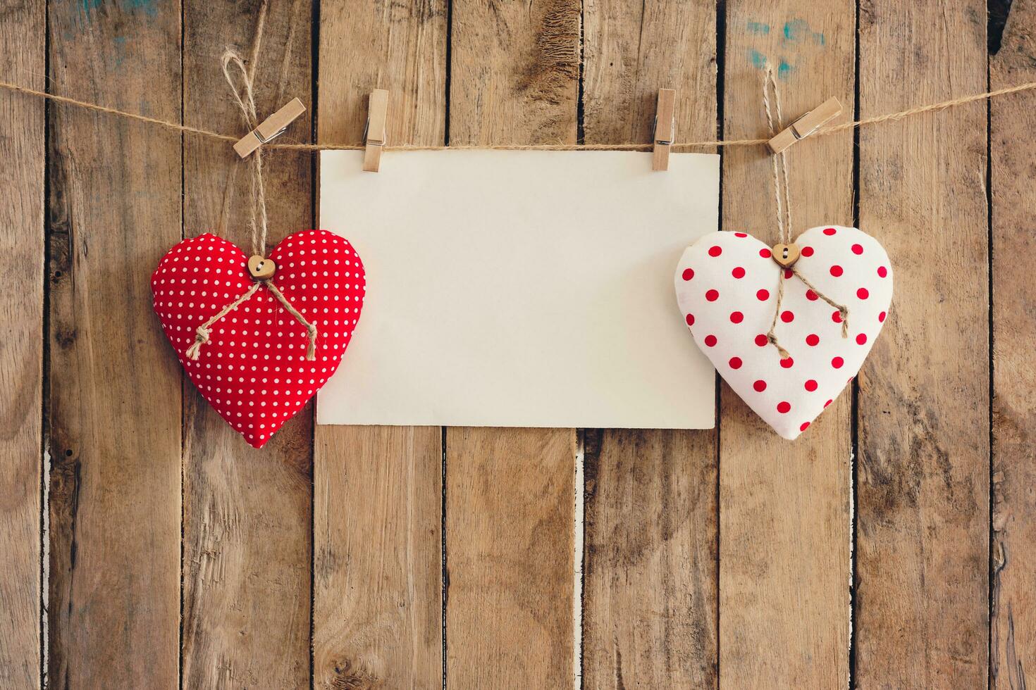 Heart and empty paper hanging on wood background with copy space. photo