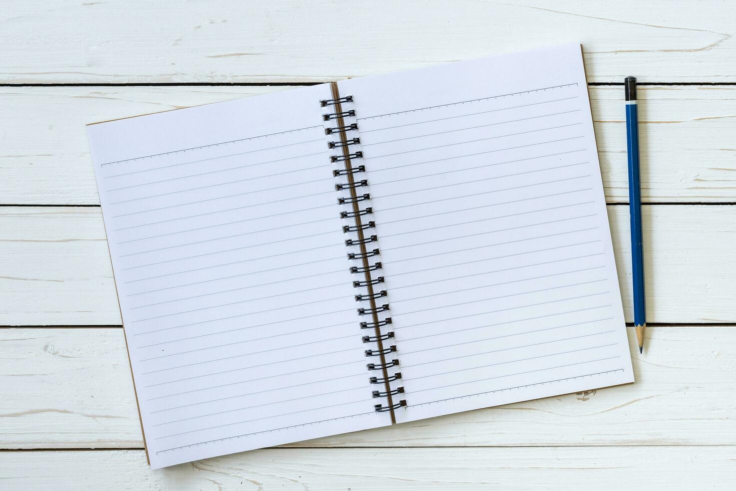 Open notebook with blank pages and pencil with space. photo