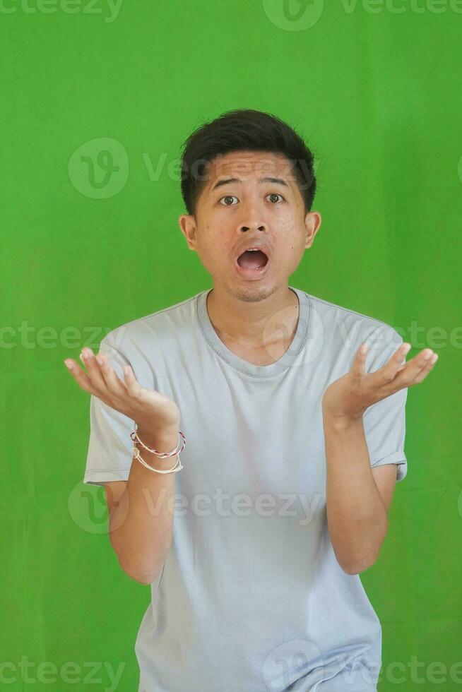 expressive casual Balinese Asian guy model for advertising with green screen studio background photo