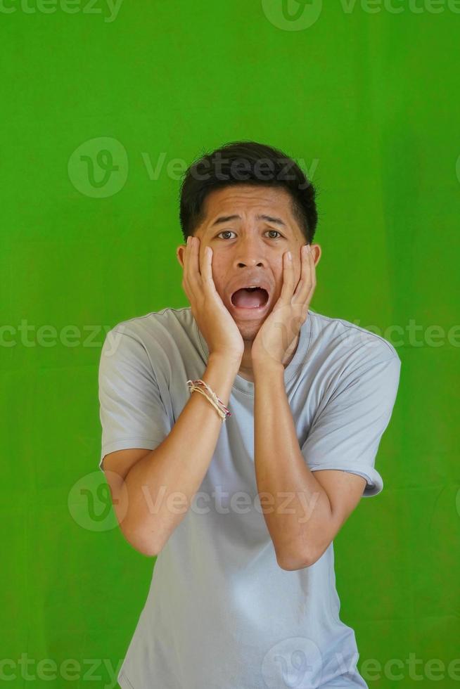 expressive casual Balinese Asian guy model for advertising with green screen studio background photo