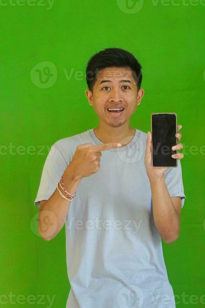 expressive casual Balinese Asian guy model for advertising with green screen studio background photo