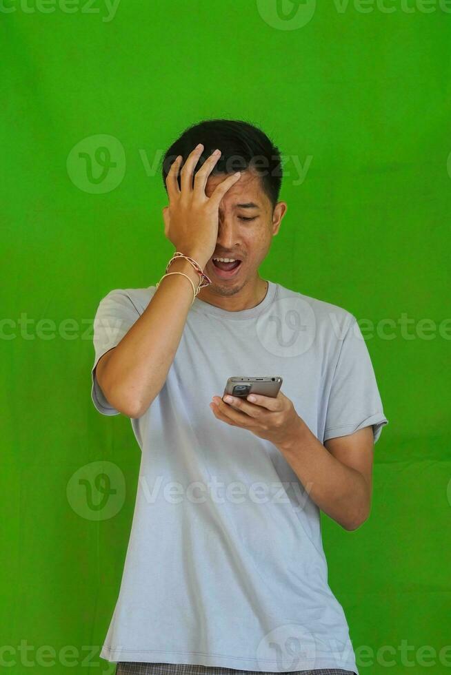 expressive casual Balinese Asian guy model for advertising with green screen studio background photo