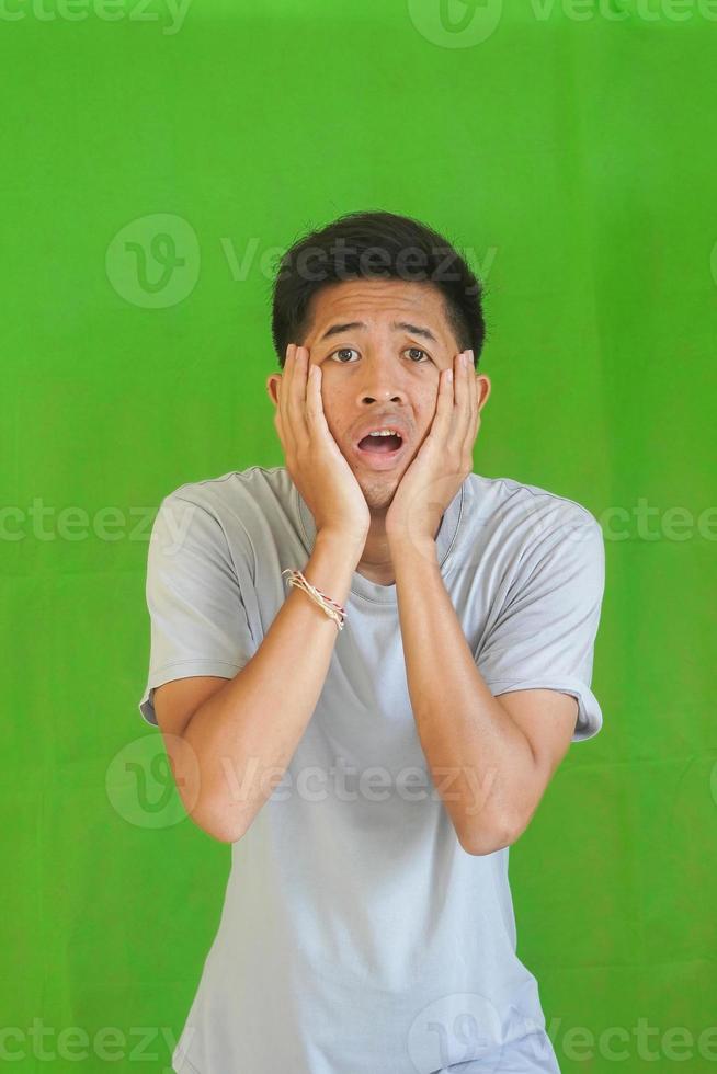 expressive casual Balinese Asian guy model for advertising with green screen studio background photo