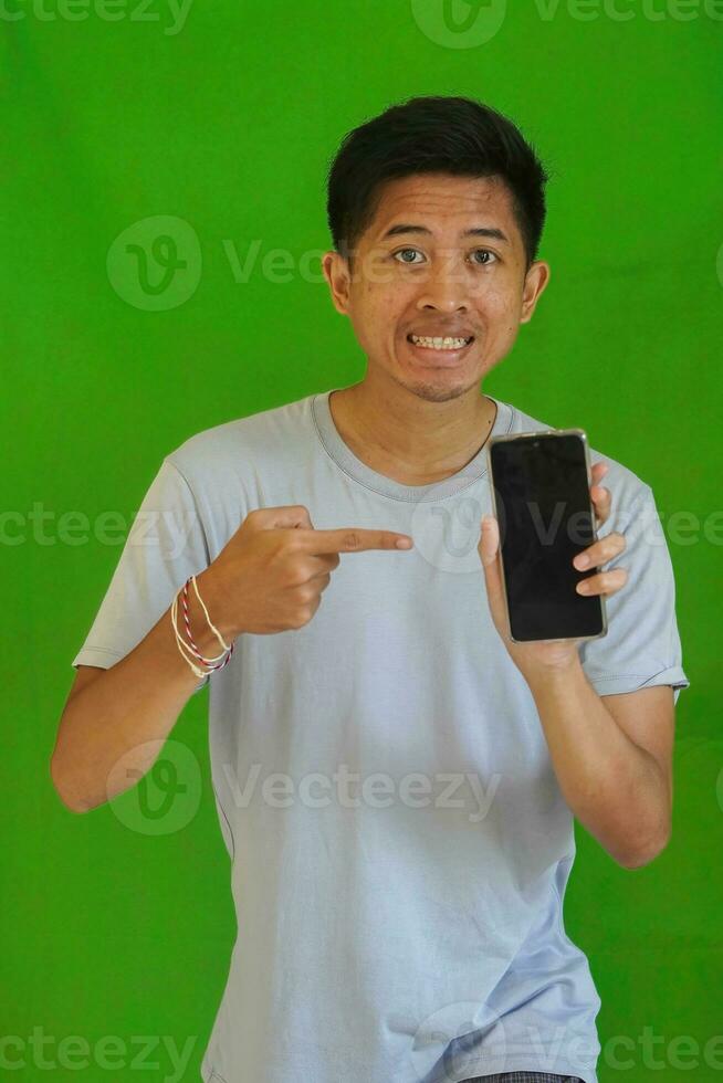 expressive casual Balinese Asian guy model for advertising with green screen studio background photo