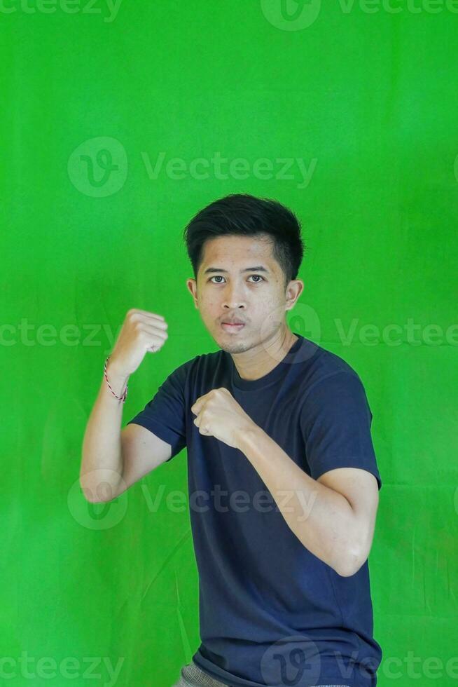 expressive casual Balinese Asian guy model for advertising with green screen studio background photo