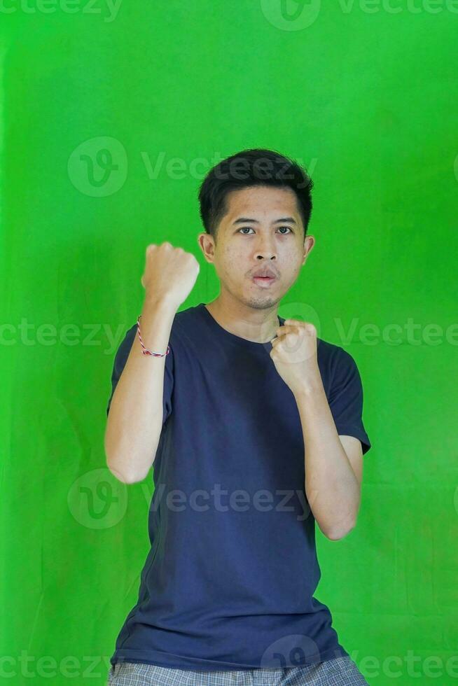 expressive casual Balinese Asian guy model for advertising with green screen studio background photo