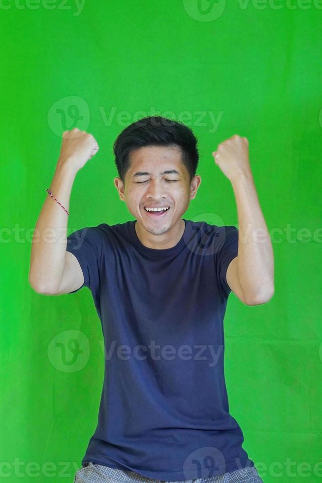 expressive casual Balinese Asian guy model for advertising with green screen studio background photo