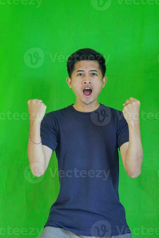 expressive casual Balinese Asian guy model for advertising with green screen studio background photo