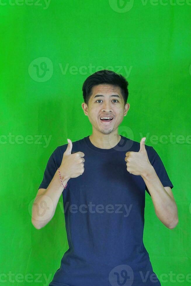 expressive casual Balinese Asian guy model for advertising with green screen studio background photo