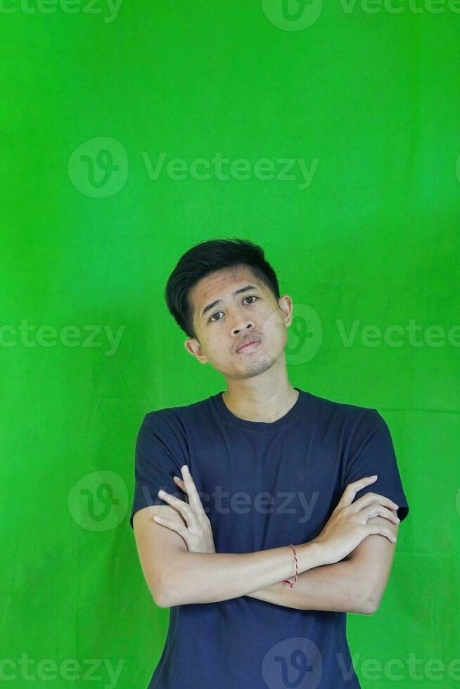 expressive casual Balinese Asian guy model for advertising with green screen studio background photo