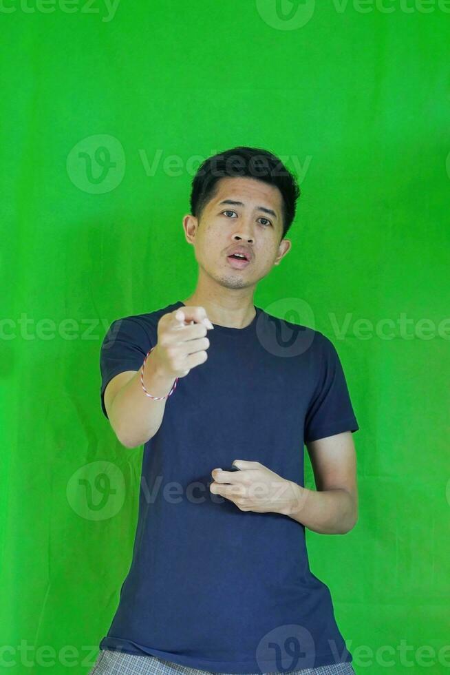 expressive casual Balinese Asian guy model for advertising with green screen studio background photo