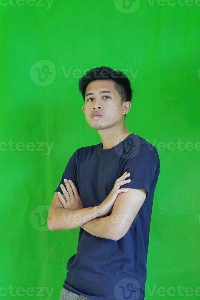 expressive casual Balinese Asian guy model for advertising with green screen studio background photo