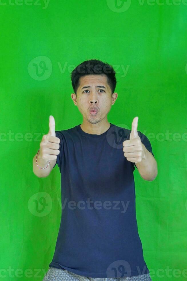 expressive casual Balinese Asian guy model for advertising with green screen studio background photo