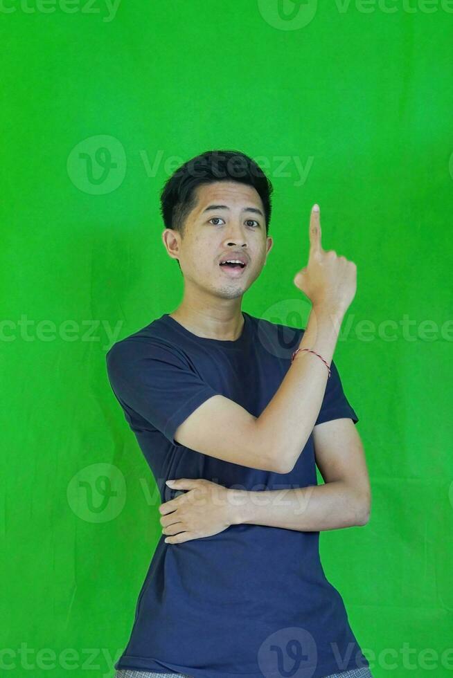 expressive casual Balinese Asian guy model for advertising with green screen studio background photo