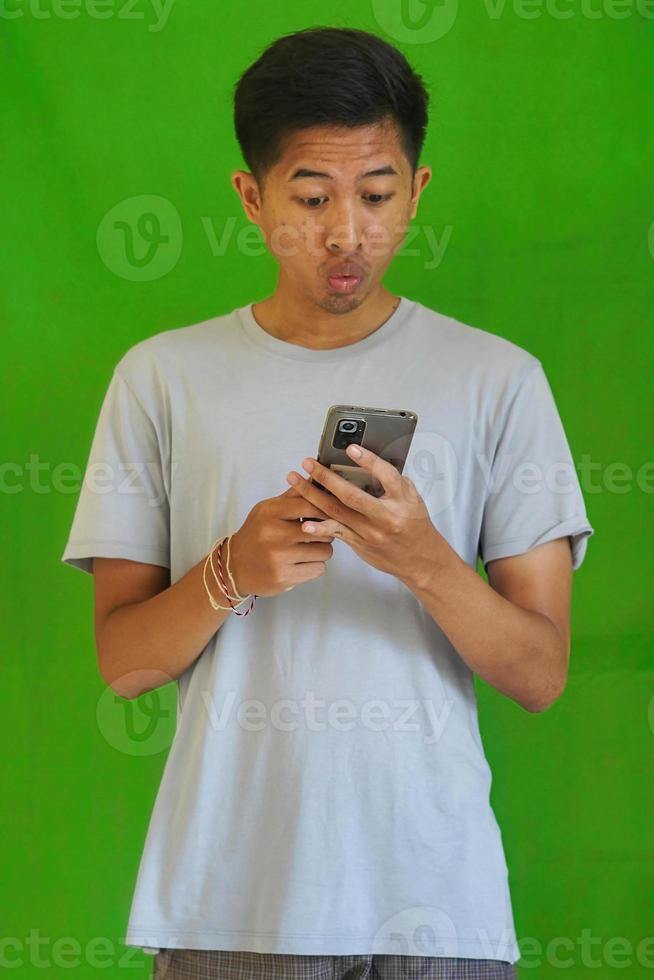 expressive casual Balinese Asian guy model for advertising with green screen studio background photo