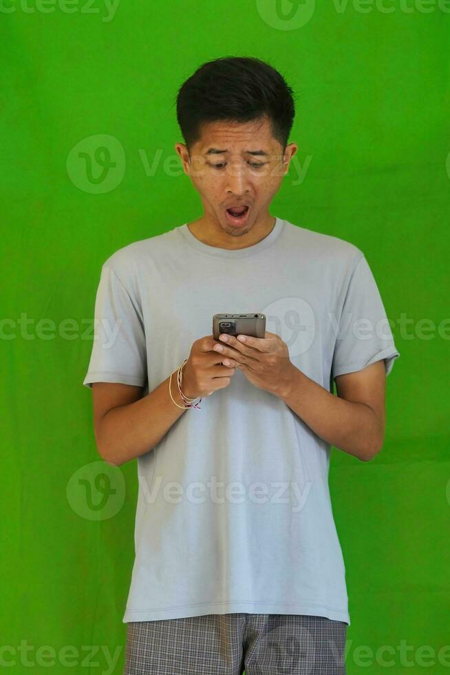 expressive casual Balinese Asian guy model for advertising with green screen studio background photo