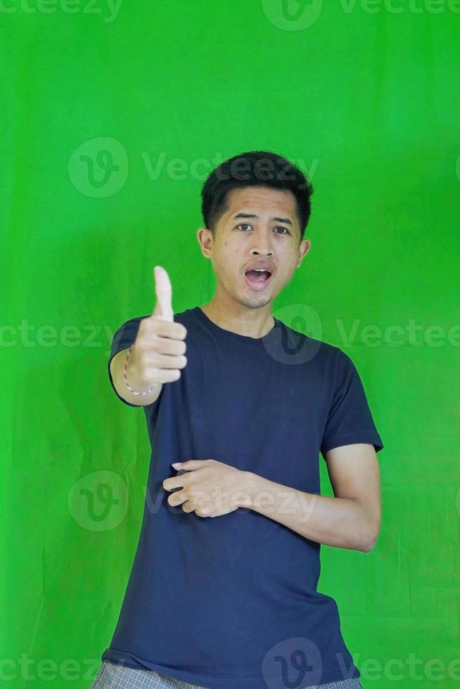 expressive casual Balinese Asian guy model for advertising with green screen studio background photo