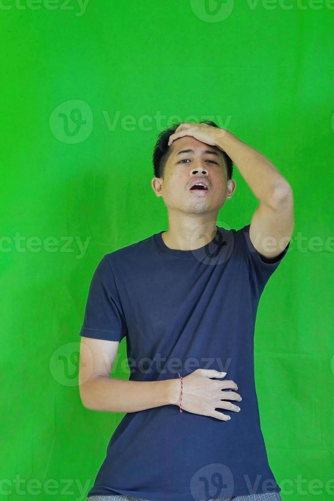 expressive casual Balinese Asian guy model for advertising with green screen studio background photo