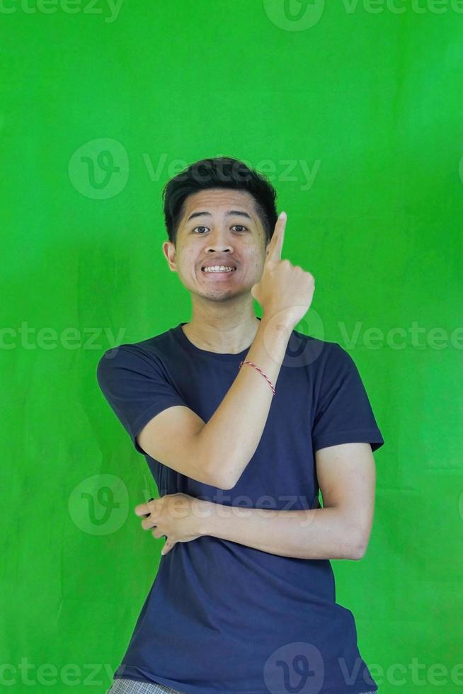 expressive casual Balinese Asian guy model for advertising with green screen studio background photo