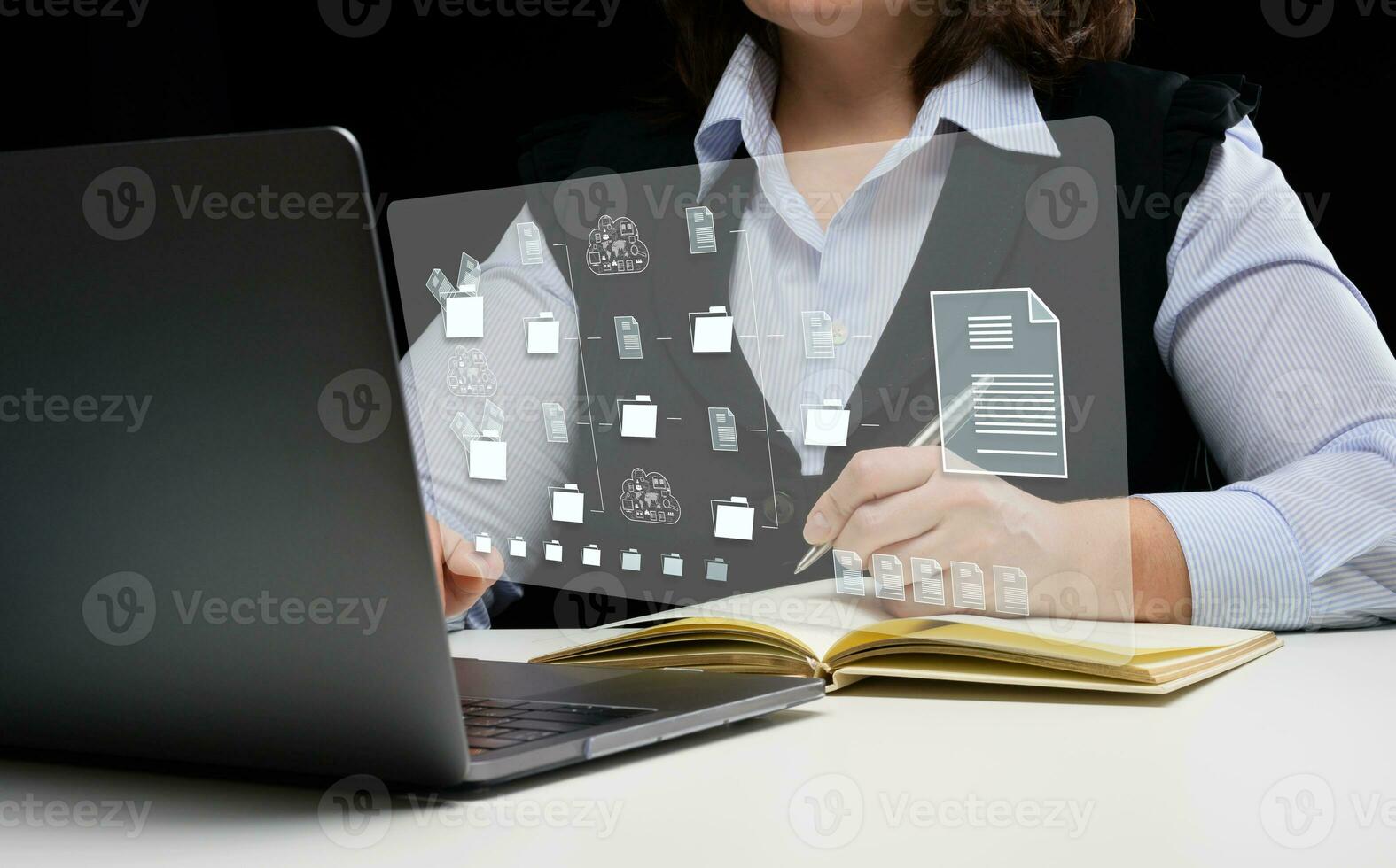 Woman sits at a table and works with a laptop. Document management system DMS photo