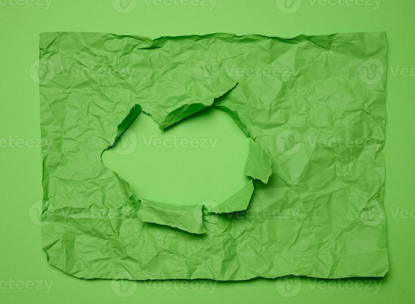 Texture of crumpled green paper with torn hole and green background, template for designer photo