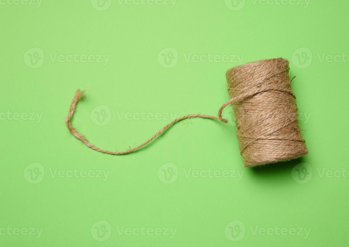 Brown thread spool on a green background, packaging rope photo