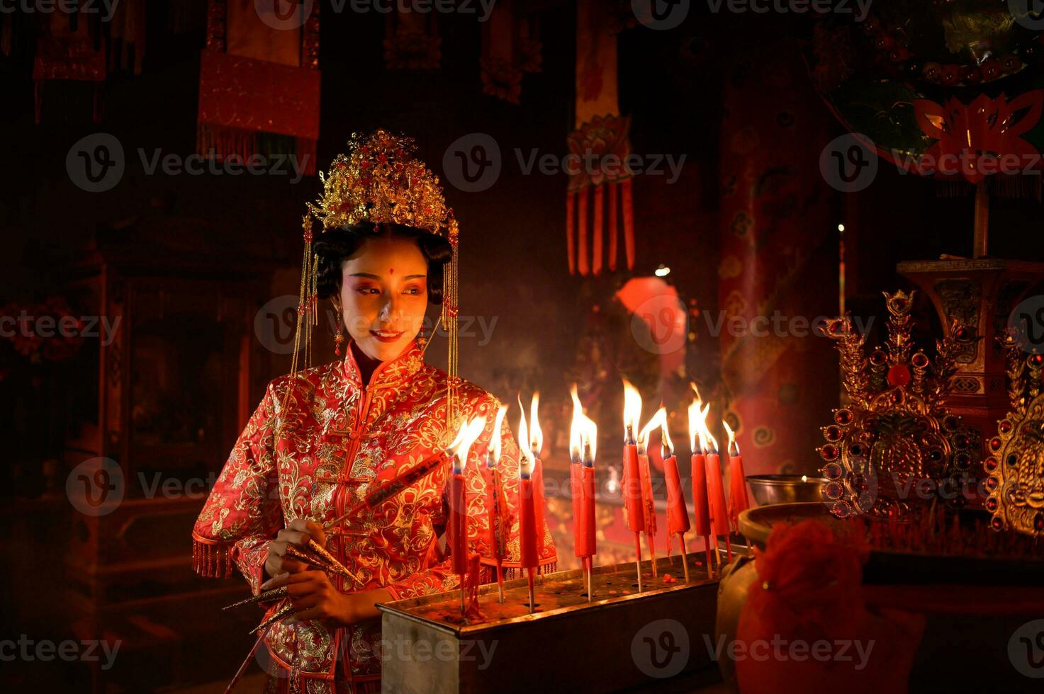 Chinese woman make wishes, pray, and light candles. On the occasion of the annual Chinese New Year festival, in a revered shrine or temple photo