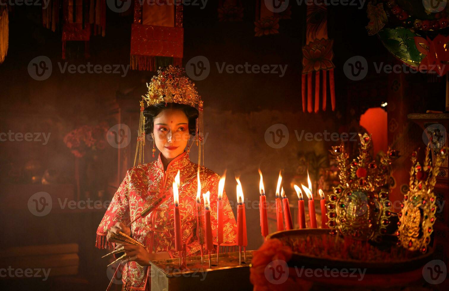 Chinese woman make wishes, pray, and light candles. On the occasion of the annual Chinese New Year festival, in a revered shrine or temple photo