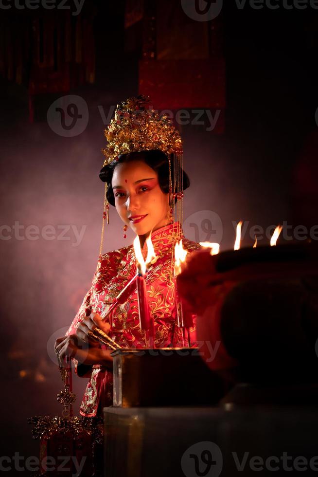 Chinese woman make wishes, pray, and light candles. On the occasion of the annual Chinese New Year festival, in a revered shrine or temple photo