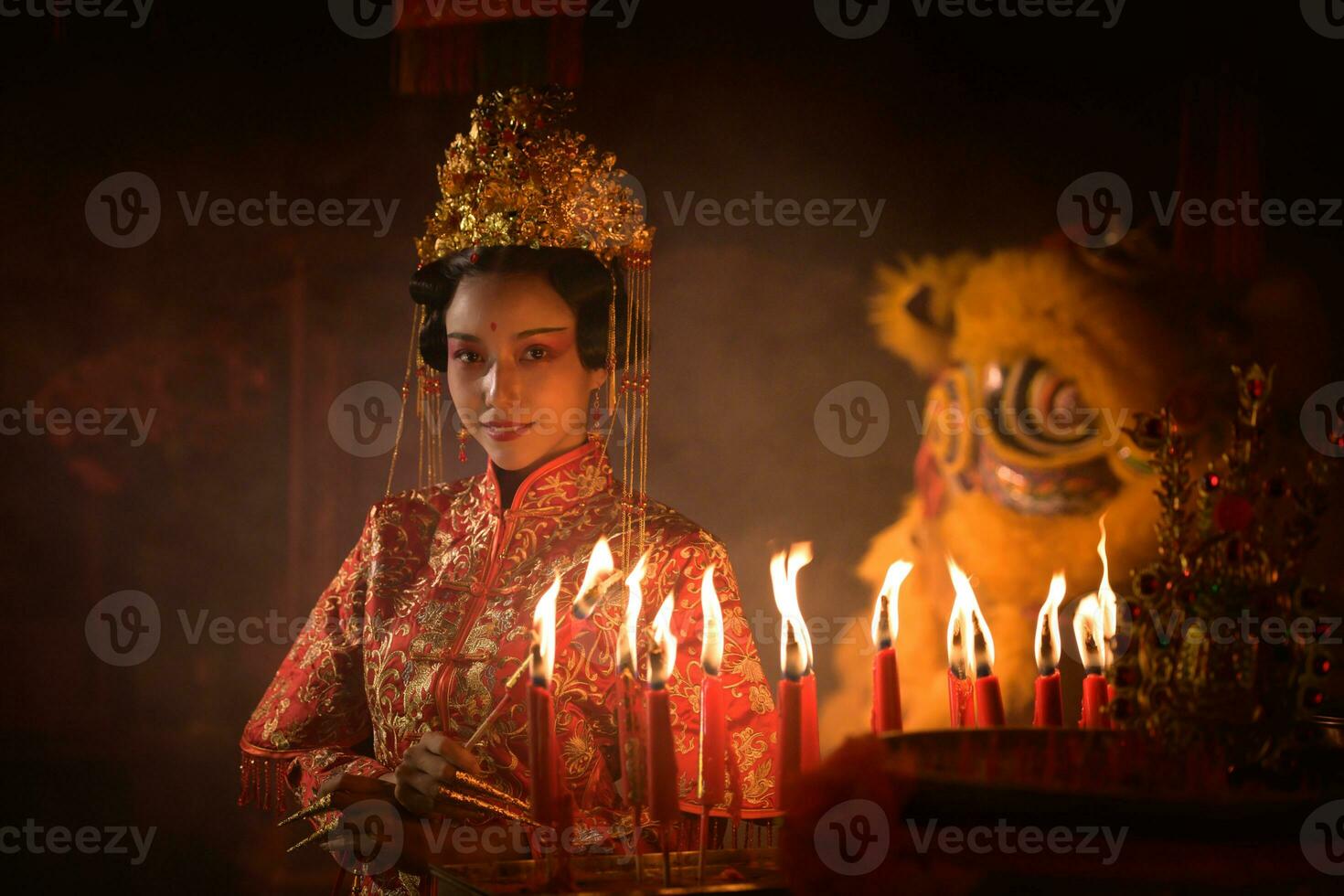 chino mujer hacer deseos, orar, y ligero velas en el ocasión de el anual chino nuevo año festival, en un venerado santuario o templo foto