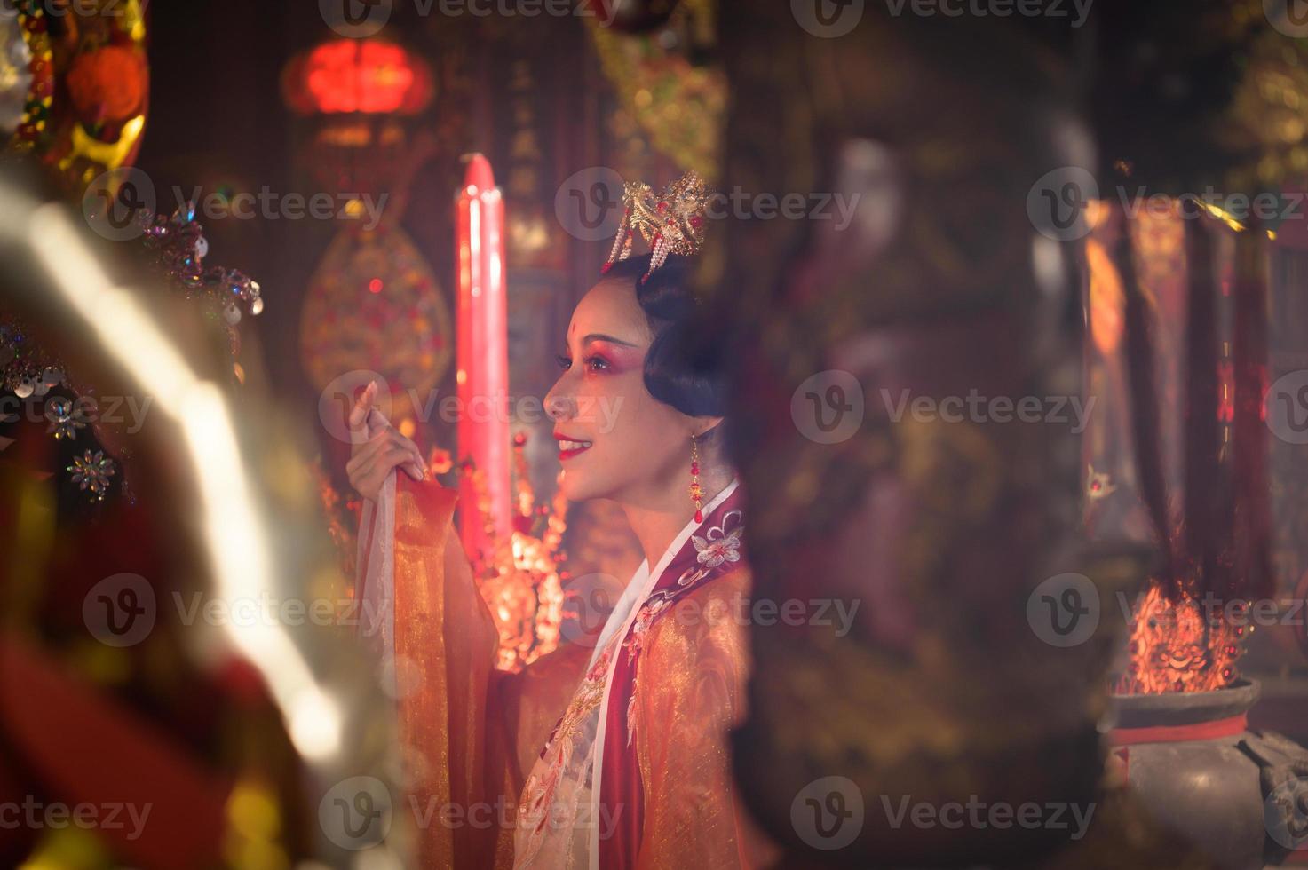 chino mujer hacer deseos, orar, y ligero velas en el ocasión de el anual chino nuevo año festival, en un venerado santuario o templo foto