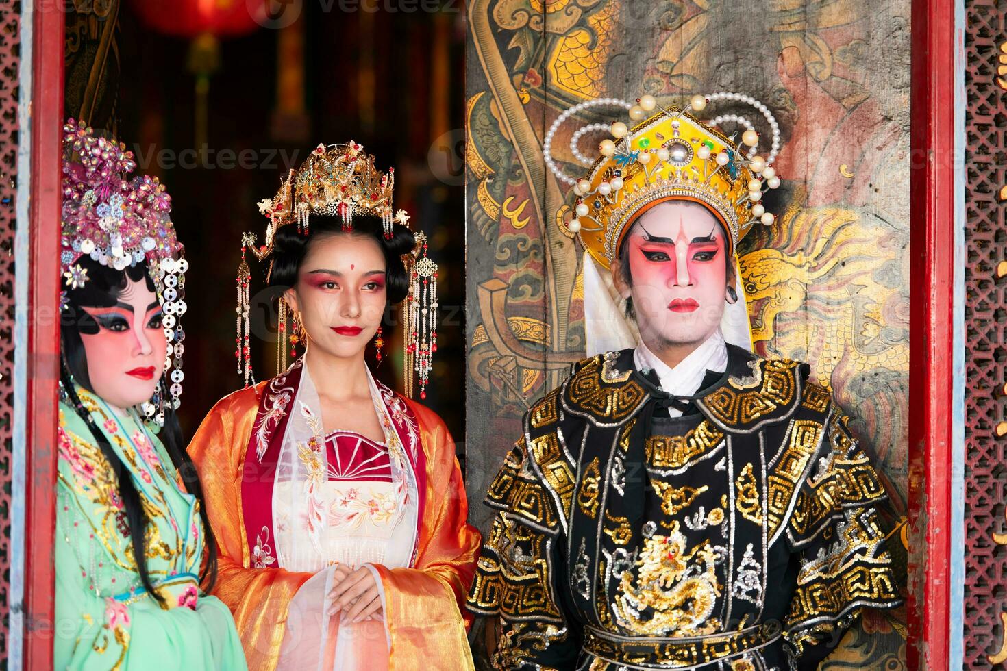Portrait of male and female opera performers at the entrance to a sacred shrine or temple, praying for blessings on the occasion of the annual Chinese New Year. photo