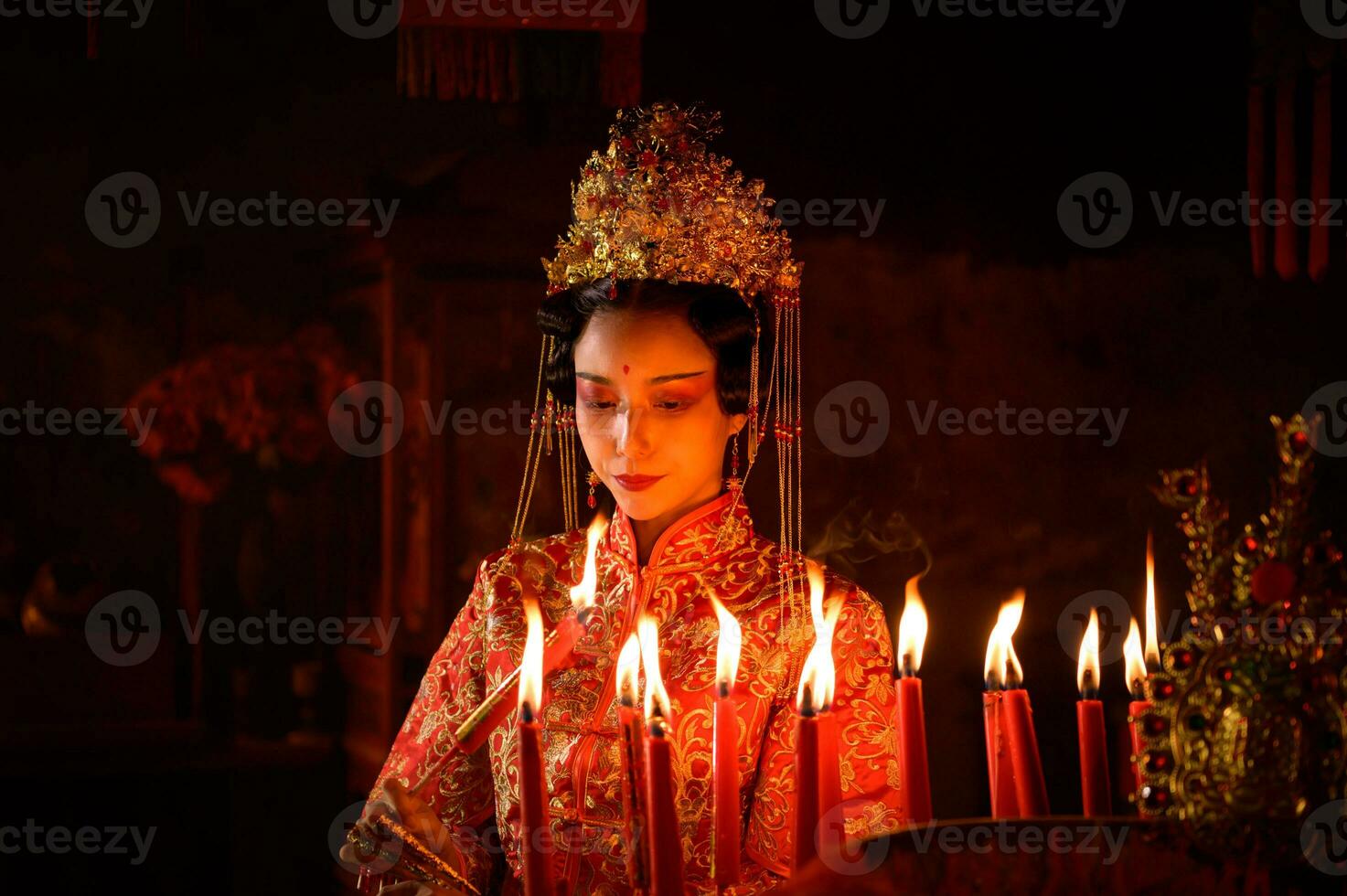 chino mujer hacer deseos, orar, y ligero velas en el ocasión de el anual chino nuevo año festival, en un venerado santuario o templo foto