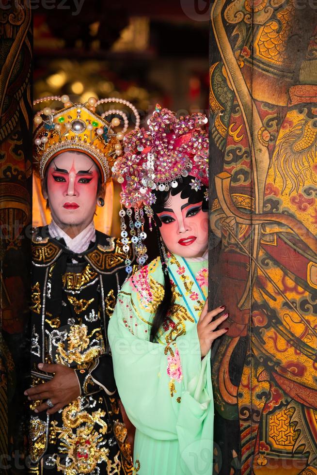 retrato de masculino y hembra ópera intérpretes a el Entrada a un sagrado santuario o templo, Orando para bendiciones en el ocasión de el anual chino nuevo año. foto