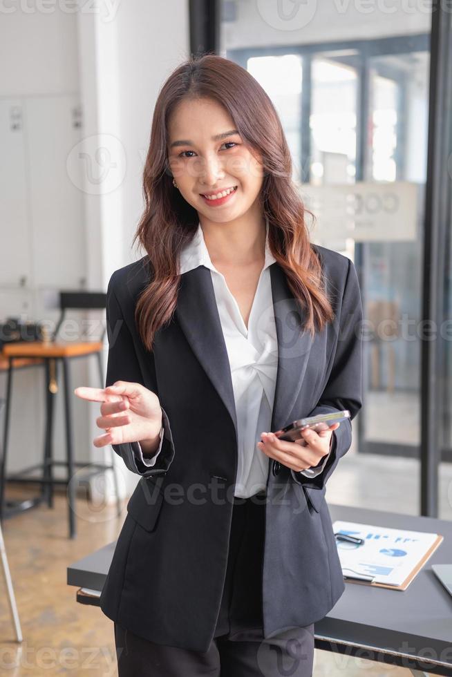 Marketing, Financial, Accounting, Planning, bAsian female entrepreneur in hand holding a smart phone Expressing joy that the company has succeeded in gaining profits from business management. photo