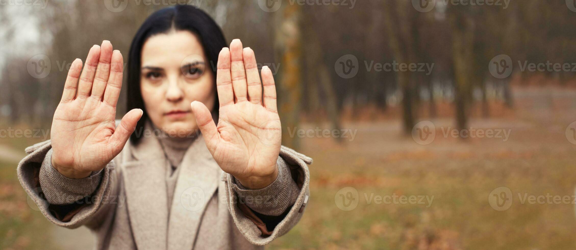 woman stretches her hands with open palms as a stop sign. photo