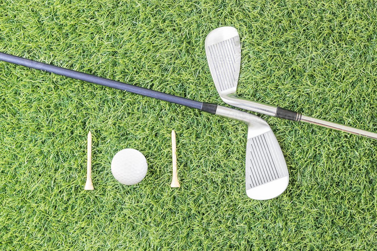 Golf club and golf ball on green grass photo