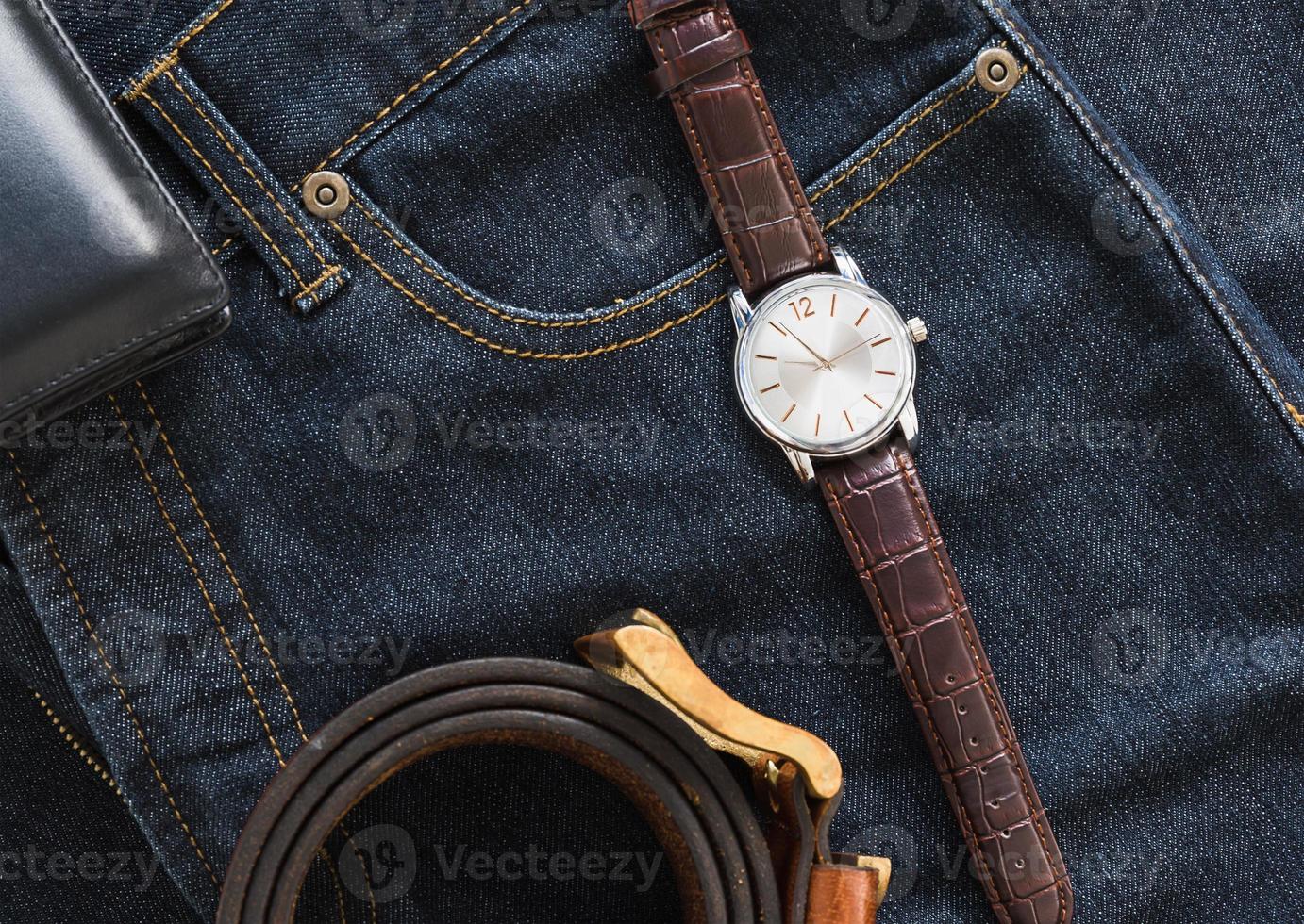 Wristwatch and wallet on denim jeans pocket photo