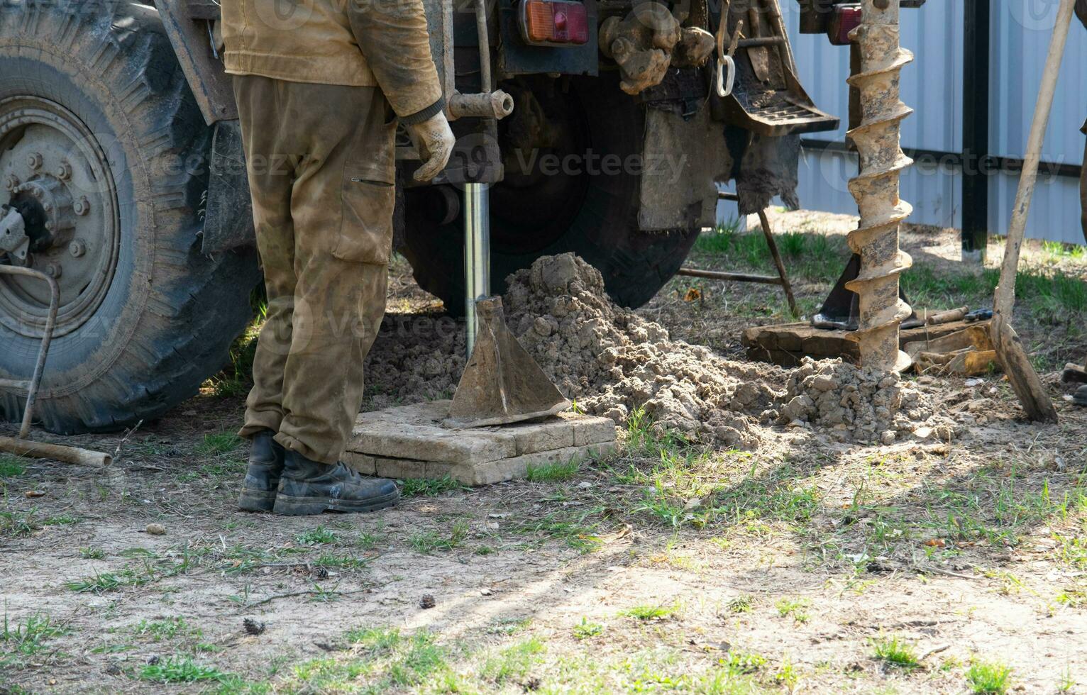 equipo de trabajadores con perforación plataforma en coche son perforación artesiano bien para agua en suelo. inserción de metal caja tubo dentro suelo, instalación de individual Bebiendo suministrar, junio 28, 2022, Rusia, foto