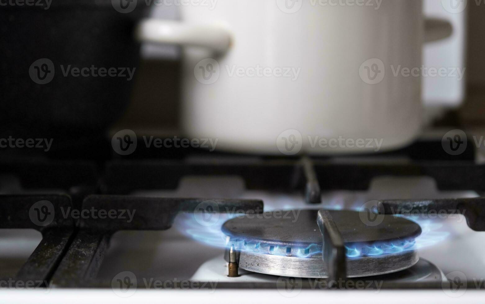 Ignition of the gas burner on the stove in the kitchen. Use of natural resources, economy, cooking on fire. Close-up photo
