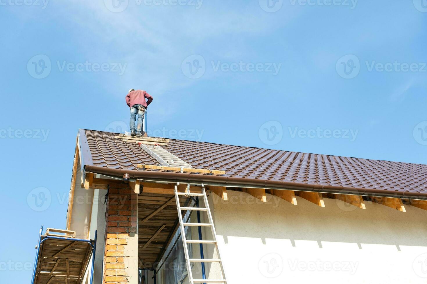 el Maestro para el instalación de ventilación tubería y el instalación de el Chimenea de el horno trabajos en el techo de el casa foto