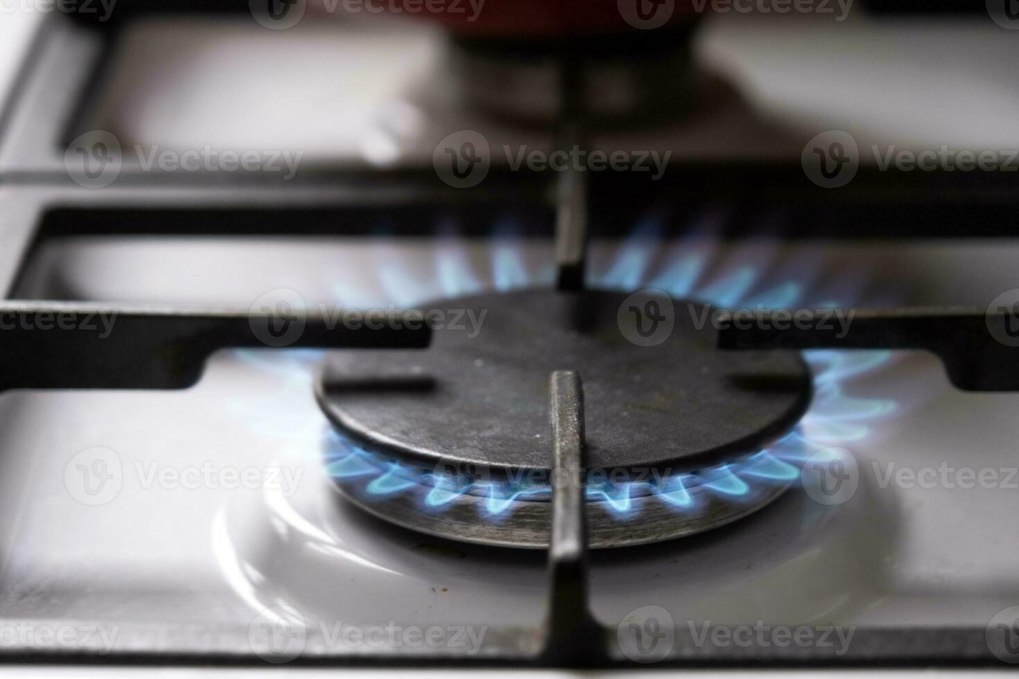 Ignition of the gas burner on the stove in the kitchen. Use of natural resources, economy, cooking on fire. Close-up photo