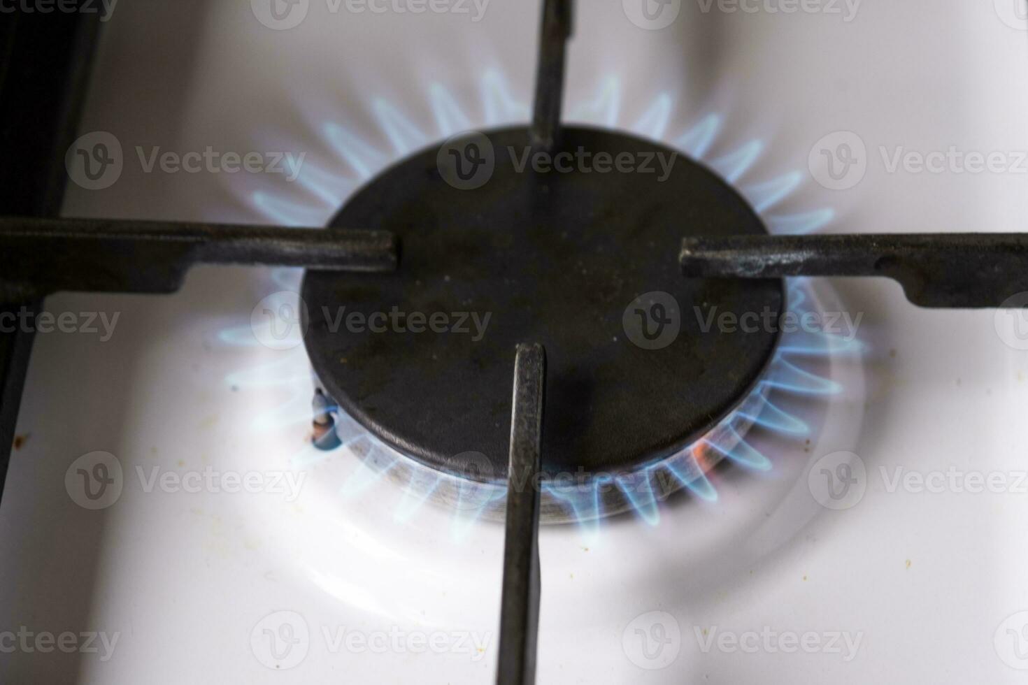 Ignition of the gas burner on the stove in the kitchen. Use of natural resources, economy, cooking on fire. Close-up photo