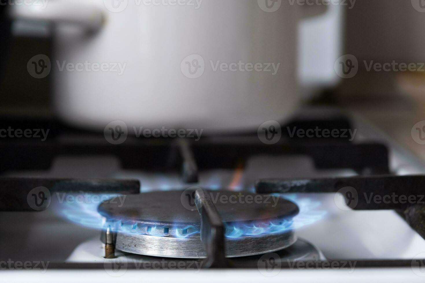 Ignition of the gas burner on the stove in the kitchen. Use of natural resources, economy, cooking on fire. Close-up photo