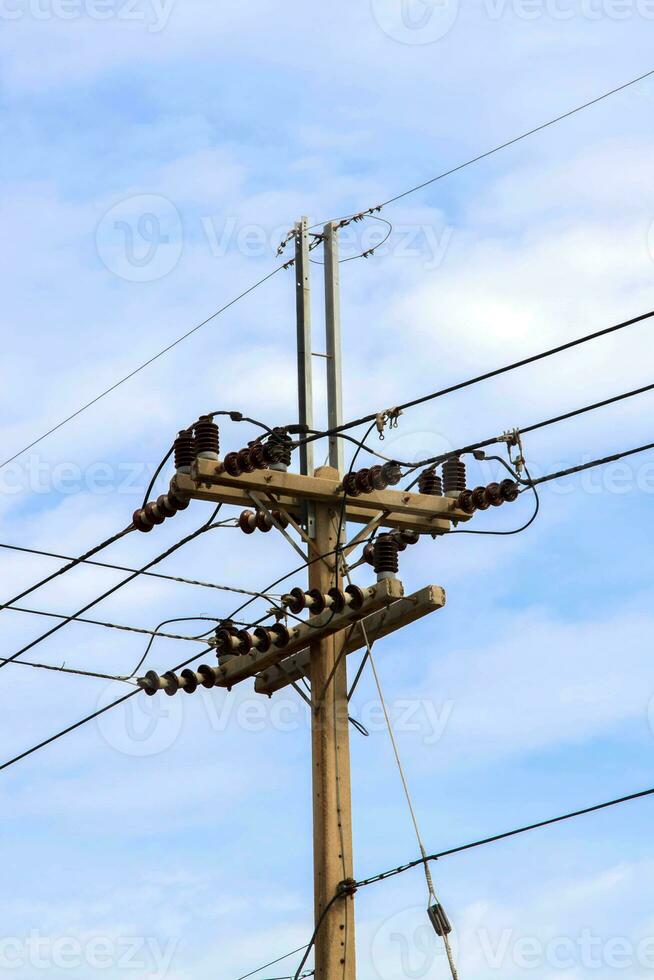 Medium voltage power lines and poles supply electricity to the people and people have used it as a modern technology designed and constructed by electrical engineering for consumer use. photo