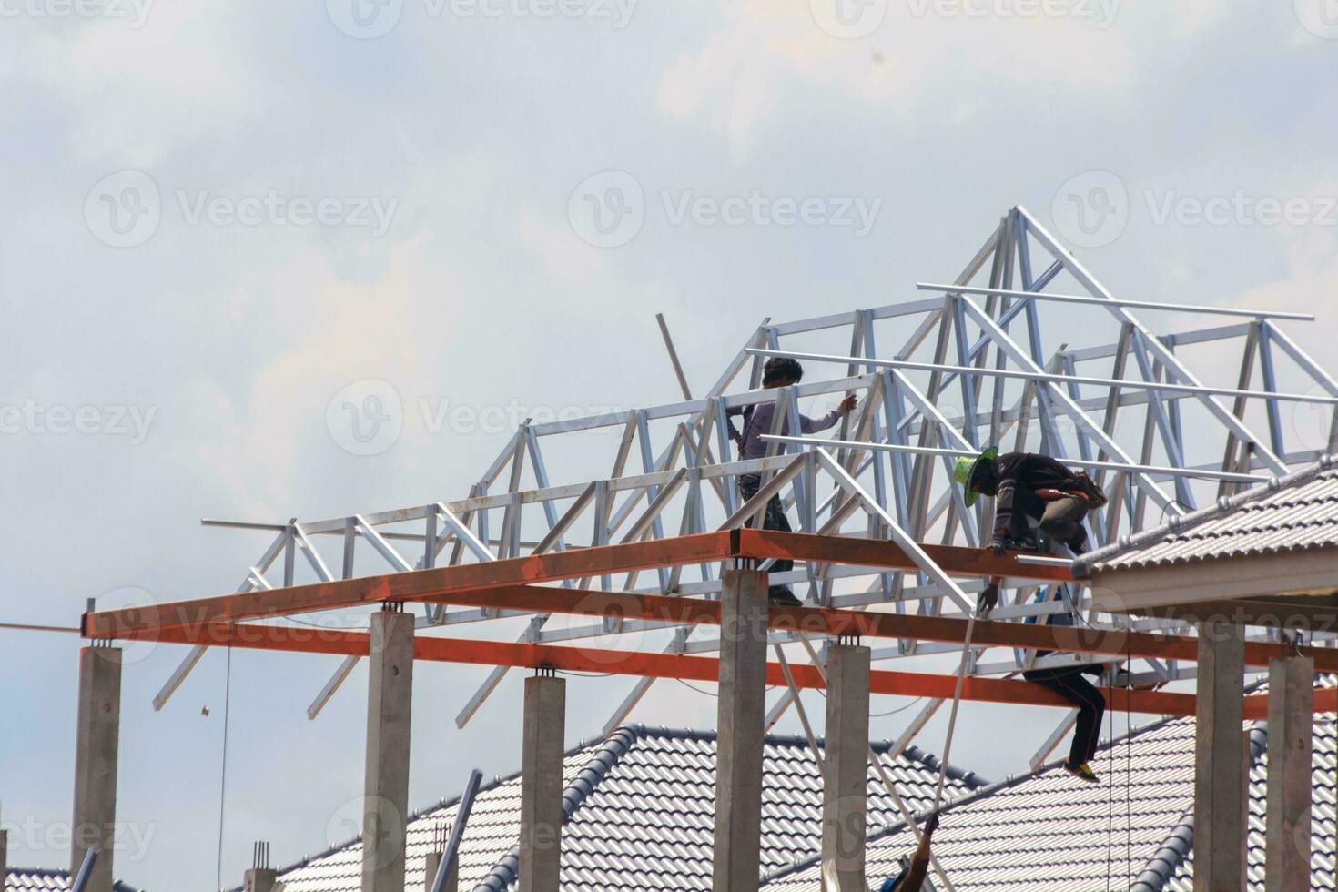 construction of a house with a thick steel frame and roofing tiles for sun and rain protection by skilled craftsmen who work at heights requires precision and extreme caution - Spanish style - photo